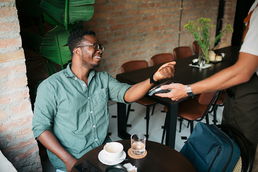 Man using his smart watch to pay at a restaurant